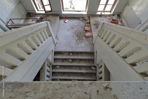 Inner stairway of an abandoned former primary school full of rubble, glass lacking window, red book on the floor. Vevchani-North Macedonia-355 photo