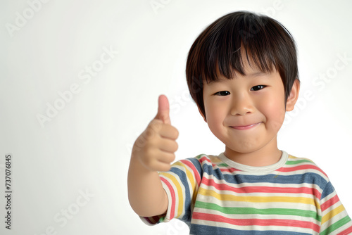 Happy little cute Asian boy giving thumbs up on white background