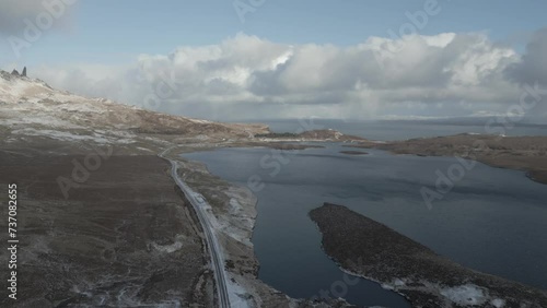 The skye bridge and loch alsh in the serene scottish highlands, with scattered snow and dynamic clouds, aerial view photo