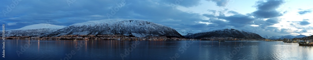 Panorama von Tromsö, Norwegen bei winterlichem Licht, Schnee, Beleuchtung, Meer, Berge, Stadt, Europa
