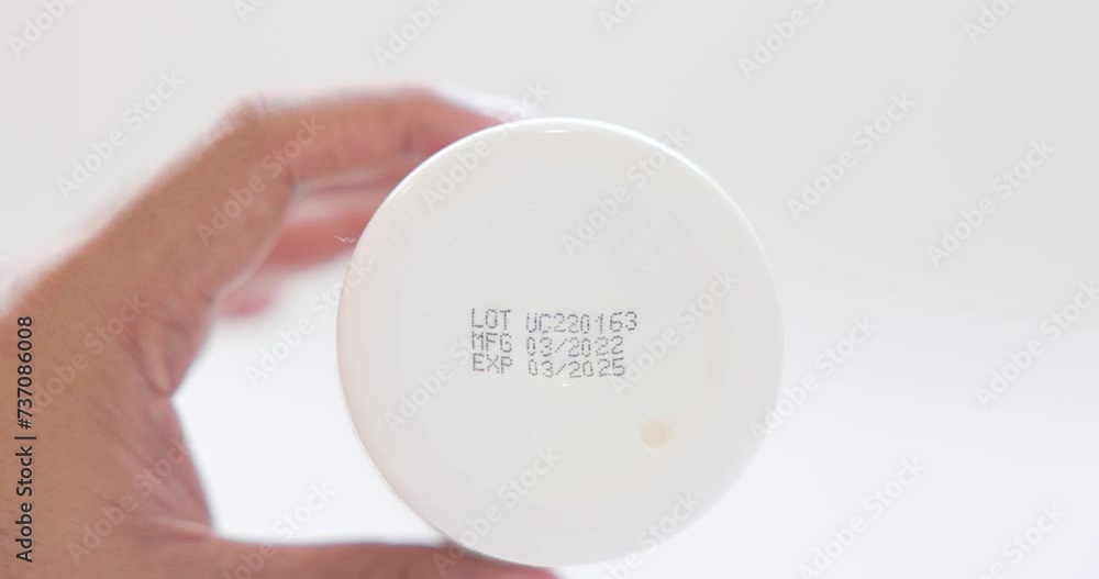 Closeup of Medicine or vitamin bottle with production date and expiration date. Reading the