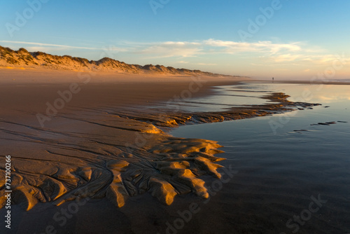 Sunset landscape of the Viago beach in Pedrogao, Figueira da Foz, Portugal, with the clouds reflected on the water. photo