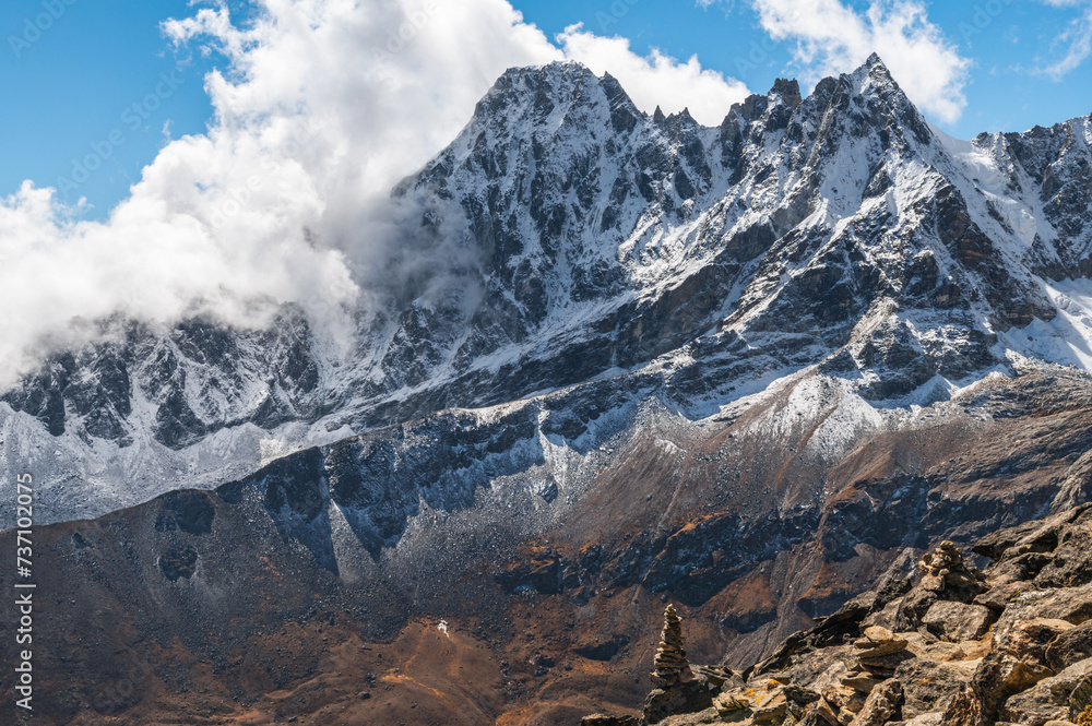 Сairn, pile of stones an, snow capped mount Phari Lapche of the Himalayas during EBC Everest Base Camp or Three Passes trekking. View from Gokyo Ri, Nepal.