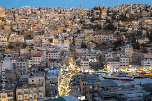 Fototapeta Naklejka Na Ścianę i Meble -  Captivating skyline of Amman, Jordan traditional houses atop a picturesque hill during blue hour