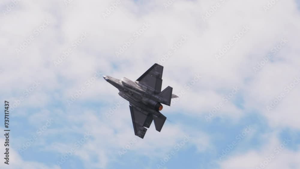 Panning Shot Of Fighter Plane Flying In Cloudy Sky On Sunny Day - Huntington Beach, California