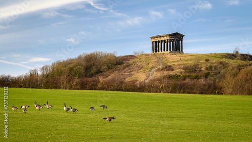Penshaw Monument and Canada Geese. Penshaw Monument is a smaller copy of the Greek Temple of Hephaestus in Athens. Erected in 1844 the folly stands 20 metres high and dominates the skyline of Wearside photo