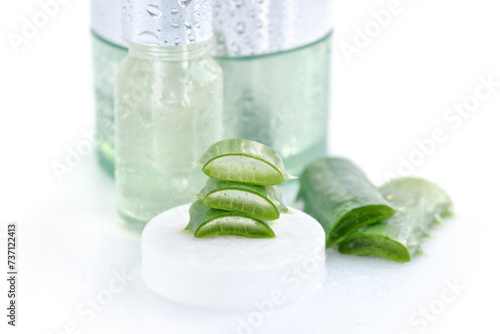 Fresh Aloe vera with aloe vera extract in glass container and water droplets on white background. Natural cosmetics concept. For Health and beauty products.