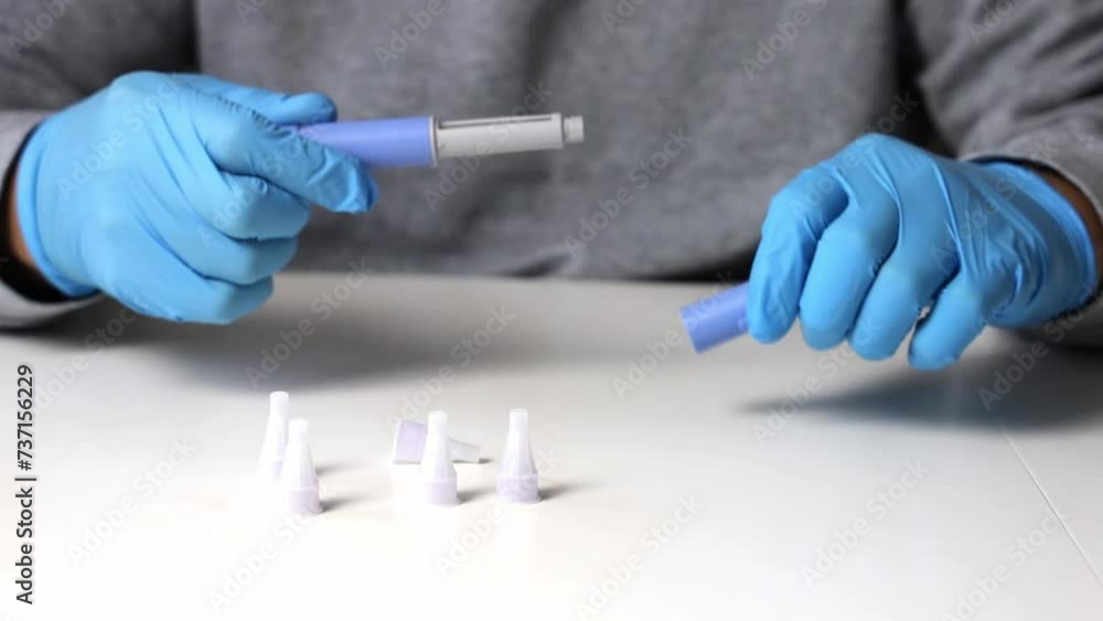 Hands in examination gloves demonstrate an injection with insulin for diabetics. Hands in examination gloves demonstrate an injection with insulin for diabetics.