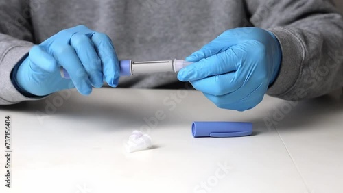 Hands in examination gloves demonstrate an injection with insulin for diabetics. photo