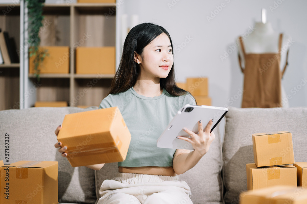 Woman start up small business owner at workplace. small business entrepreneur SME or freelance asian woman working with box at home.. Woman start up small business owner at workplace. small business entrepreneur SME or freelance asian woman working with box at home..