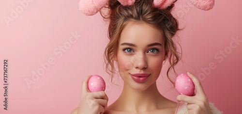 woman with rabbit ears with easter eggs on pink background