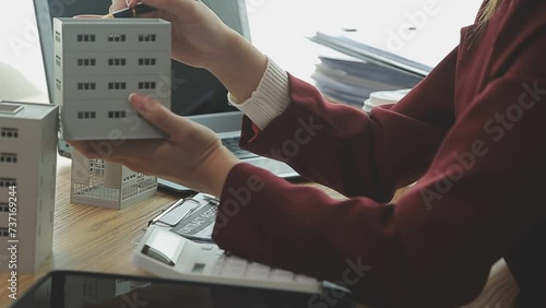 Person Hand Doing Property Tax Calculation Using Calculator Of House Model photo