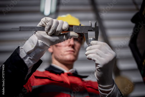 Industry engineer wearing safety uniform used vernier caliper to measure the object control operating machine working in industry factory is metal manufacturing machine industry concept.