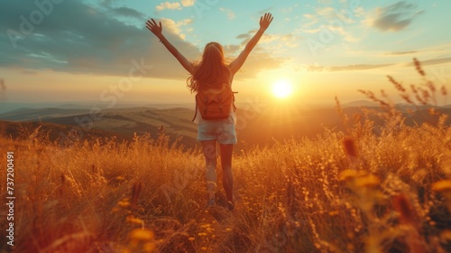 Joyful Woman with Arms Raised Embracing the Warmth of a Golden Sunset