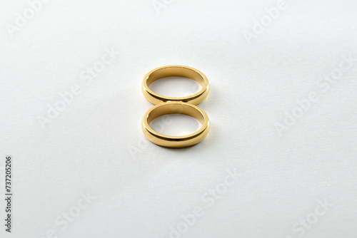 Engagement gold rings forming an eight on a white base