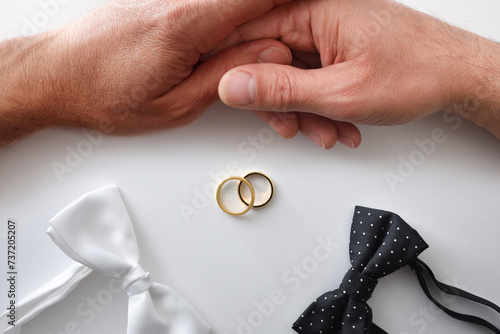 Gay wedding conceptual background with couple rings and bow ties