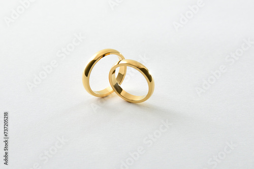 Engagement gold rings standing perpendicular to each other isolated white