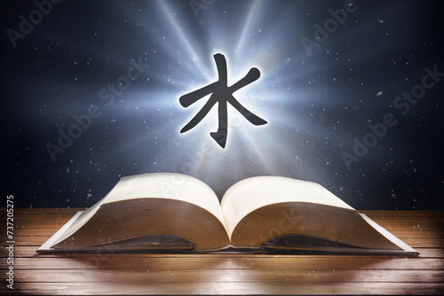 Open book on wooden table and confucianism symbol front view