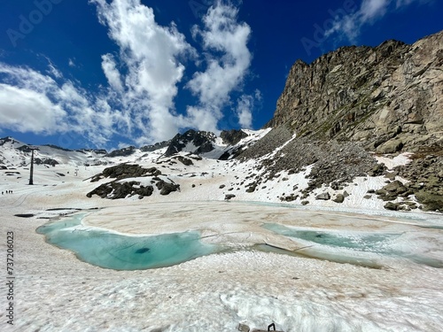 Snow, mountain lake and Presena glacier in italy photo