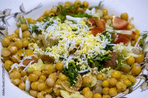 Spicy Chotpoti with chaat masala, chana, chola, chili, and egg served in a dish. Traditional Bangladeshi, Indian, and Pakistani food. Delicious Asian street food.  photo