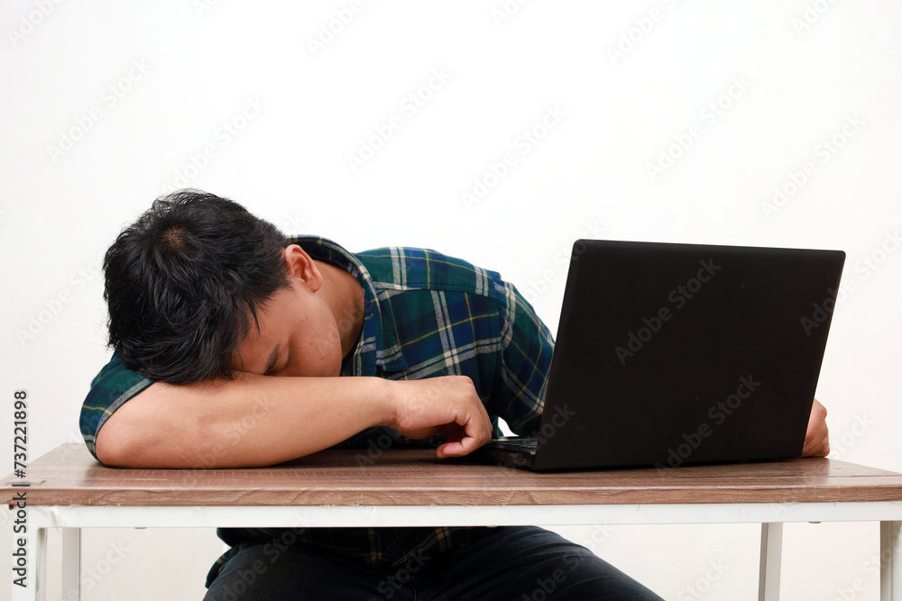 Young asian college student sleeping while sitting with laptop on the desk Young asian college student sleeping while sitting with laptop on the desk