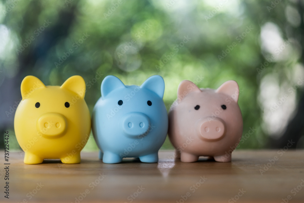 Three piggy banks sitting side by side on table. Can be used to represent savings, financial planning, or budgeting concepts. Three piggy banks sitting side by side on table. Can be used to represent savings, financial planning, or budgeting concepts.