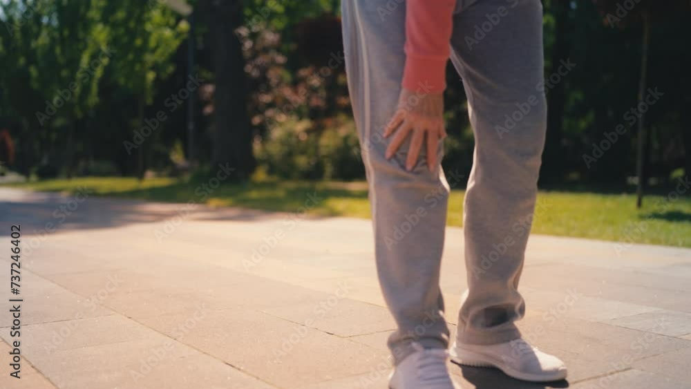 Senior woman suffering strong knee pain while running in park, arthritis symptom Senior woman suffering strong knee pain while running in park, arthritis symptom