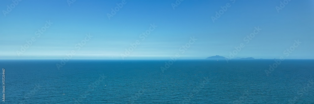 Serene ocean view with distant mountains under a clear blue sky, perfect for travel and vacation-themed designs