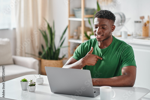 african american man communicating with sigh language during online meeting on laptop, virtual photo