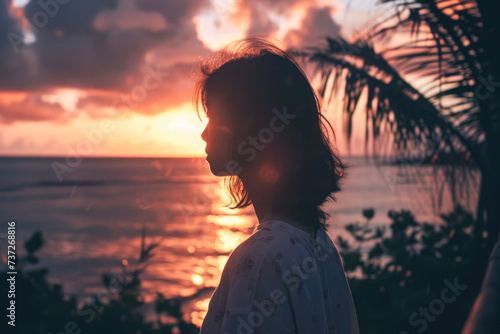 Silhouette of a girl on the background of the sea and sunset