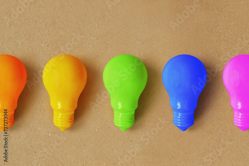 Φωτογραφία Light bulbs in different colors on recycled paper background - Concept of creati