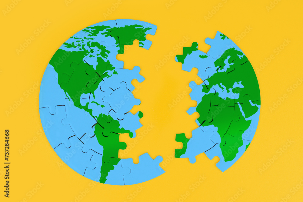 Globe Puzzle Split into Two Parts on Yellow