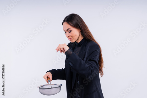 Happy young blonde woman sifts through a sieve on red white bsckground in studio photo