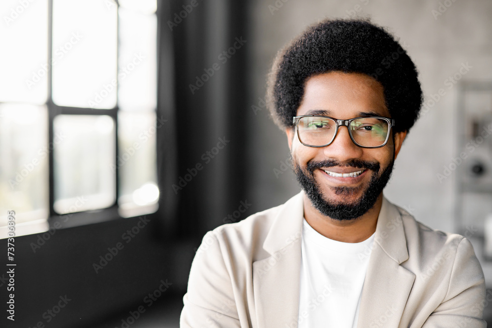 Young Brazilian businessman with a charming smile stands confidently, looking at the camera with friendly smile. The minimalist background emphasizes his modern approach to business and connectivity Young Brazilian businessman with a charming smile stands confidently, looking at the camera with friendly smile. The minimalist background emphasizes his modern approach to business and connectivity