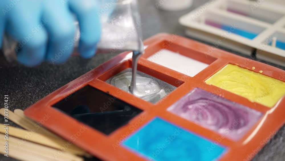 Process of pouring silver colour epoxy resin from plastic cup into silicone mold, epoxy resin colours samples formation in carpentry workshop, handmade epoxy design for furniture or accessories Process of pouring silver colour epoxy resin from plastic cup into silicone mold, epoxy resin colours samples formation in carpentry workshop, handmade epoxy design for furniture or accessories