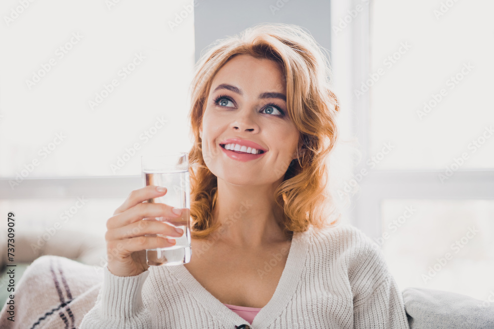 Photo of pretty positive lady toothy smile hand hold glass water look away imagine free time apartment indoors Photo of pretty positive lady toothy smile hand hold glass water look away imagine free time apartment indoors
