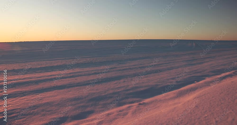 winter field covered with snow at sunset, beautiful multicolored sky at sunset in winter winter field covered with snow at sunset, beautiful multicolored sky at sunset in winter