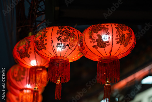 Illuminated Red Chinese Lanterns Against Dark Background © Maria