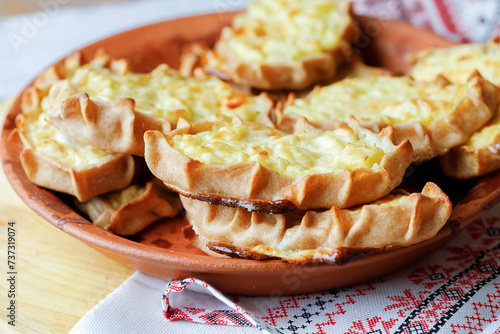 Karelian plays or Karjalanpiirakka. Traditional finnish or north russian pastry on clay plate. photo