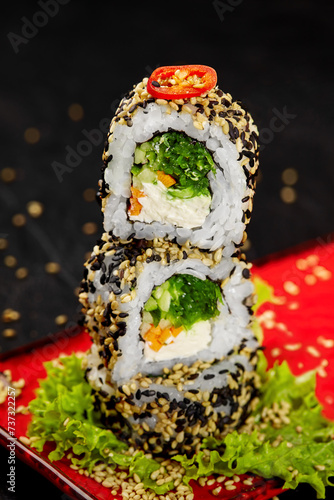 Stack of light vegetarian sushi rolls on red plate