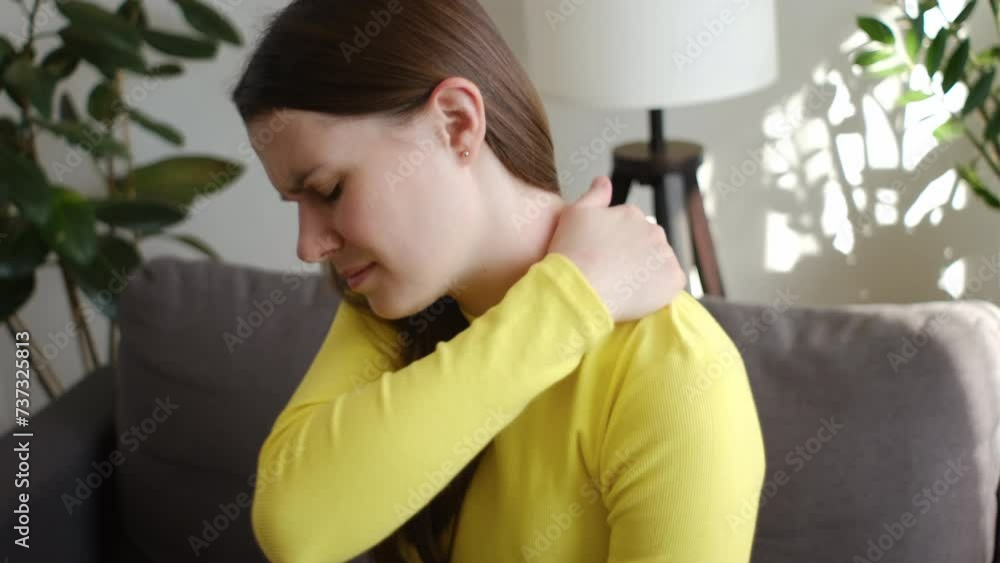 Pain body muscles stiff problem, upset young caucasian woman holding neck ache from work, sad female massaging rubbing shoulder hurt, sore sitting alone on couch at home. Health care concept Pain body muscles stiff problem, upset young caucasian woman holding neck ache from work, sad female massaging rubbing shoulder hurt, sore sitting alone on couch at home. Health care concept