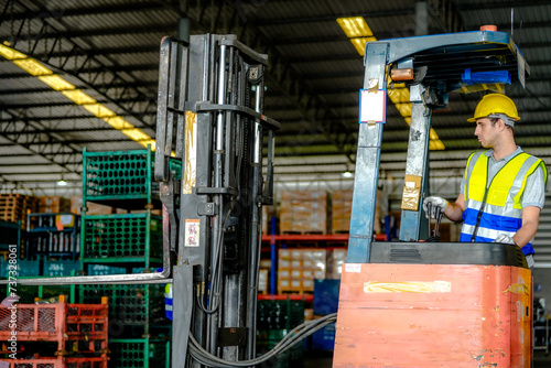factory man driving forklift car working in distribution warehouse. factory worker teammates working beside stacks of cargo. Group of Diversity engineer factory people meeting.