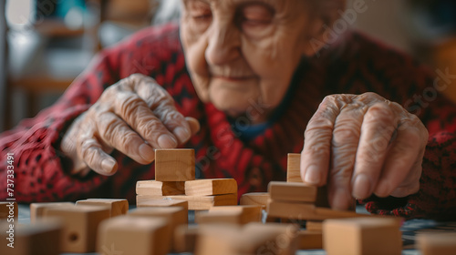 Elderly woman playing with wooden blocks in a geriatric clinic or nursing home photo