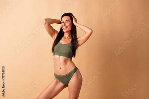 Photo portrait of attractive young woman touch head cool model no retouch wear trendy khaki lingerie isolated on beige color background