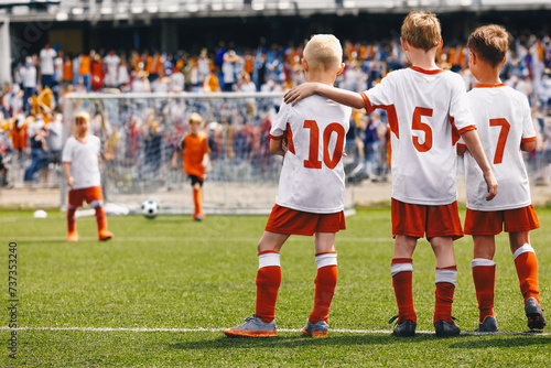 School Boys as Soccer Friends Teammates. Kids United in a Sports Team During Penalty Kick Game. Children in Football Uniforms at a Sports Arena Playing a Final Match. Young Players Supports Each Other