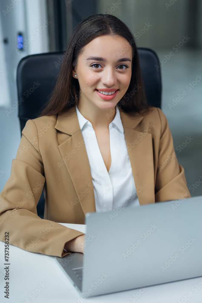 Portrait of happy and successful female programmer inside office at workplace, worker smiling and looking at camera with laptop Portrait of happy and successful female programmer inside office at workplace, worker smiling and looking at camera with laptop