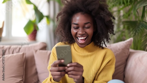 Laughing black woman with a mobile phone. The concept of joy and social media.