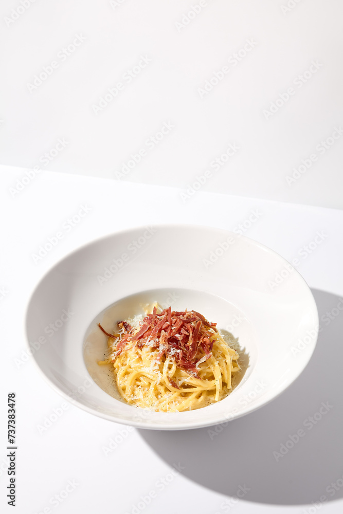 Classic Italian Carbonara Pasta with Bacon, Cheese, and Egg Yolks, Served in a White Bowl for a Traditional Culinary Experience Classic Italian Carbonara Pasta with Bacon, Cheese, and Egg Yolks, Served in a White Bowl for a Traditional Culinary Experience