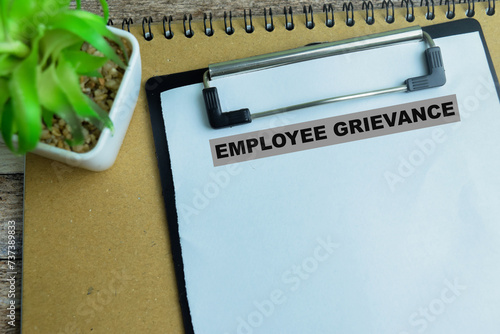 Concept of Employee Grievance write on paperwork isolated on wooden background.