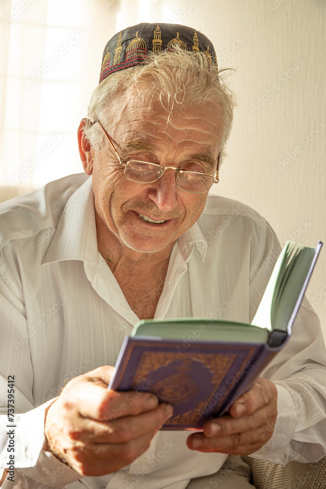 Lifestyle portrait of senior islamic man reading Quran at home. Natural aesthetic light Lifestyle portrait of senior islamic man reading Quran at home. Natural aesthetic light